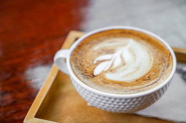 Ahşap masadaki Latte Kahve Sanatı .