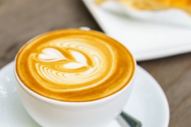Ahşap masadaki Latte Kahve Sanatı