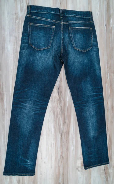 Calça jeans azul com preço no fundo de madeira  . — Fotografia de Stock