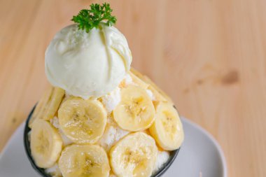 Korece stil bing su taze muz tıraş buz üzerinde ahşap masa .