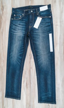 Mavi jeans ahşap arka plan üzerinde fiyat etiketi ile .