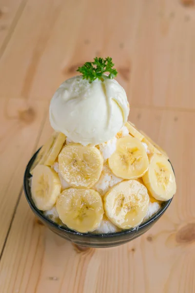 Koreanischer Stil bing su frische Banane rasiert Eis auf Holztisch . — Stockfoto