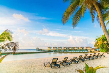 Plaj sandalyeleri Maldivler Island ile güneşin doğuşunu, su Villa