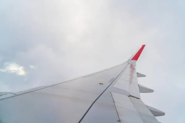 Asa de um avião voando acima das nuvens . — Fotografia de Stock