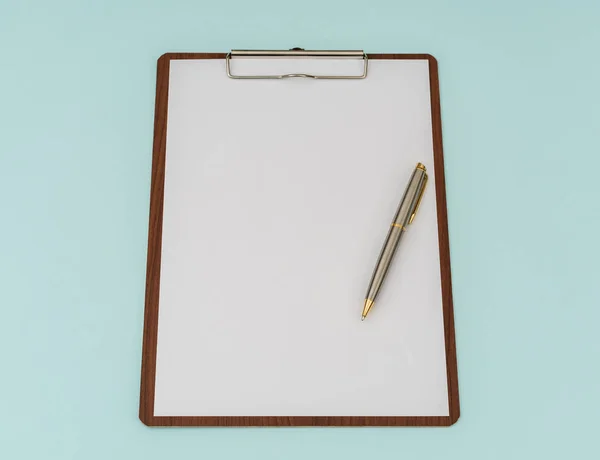 Clip boord, pen en papier op blauwe achtergrond . — Stockfoto