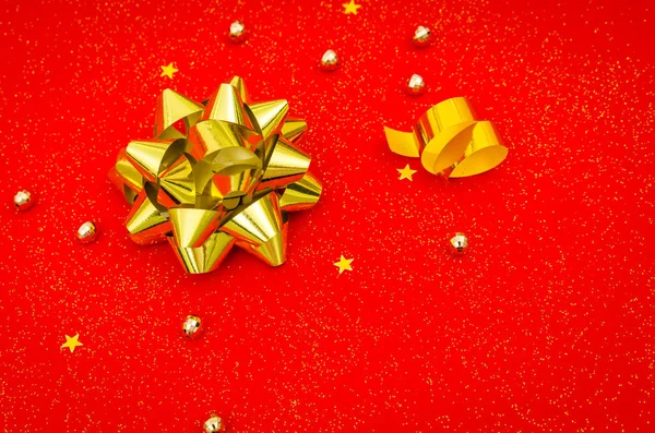 Gold ribbon with bow on red background . — Stock Photo, Image