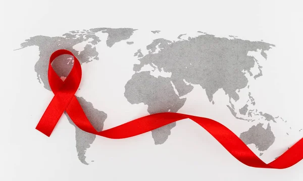 Sensibilisation au sida Ruban rouge sur la carte du monde  . — Photo