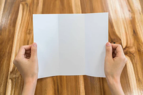 Nők kézzel tartsa levél fehér sablon papír, a fa texture . — Stock Fotó