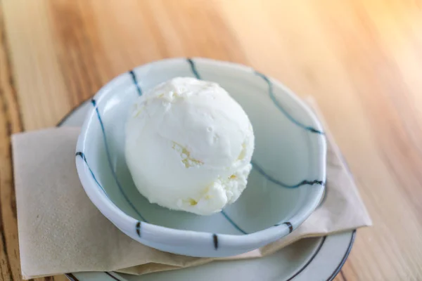 나무 탁자 위에 놓인 그릇에 담겨 있는 밀크 아이스크림 . — 스톡 사진