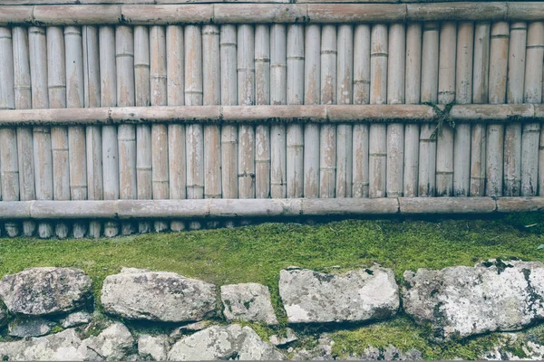 Cerca de bambu em pedra com folhas verdes. (Imagem filtrada proc — Fotografia de Stock