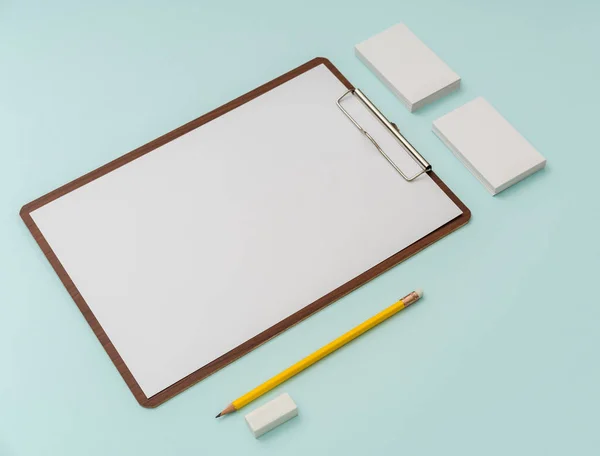 Clipboard, Papier, Bleistift und Visitenkarte auf blauem Hintergrund . — Stockfoto