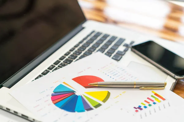 Gráficos financieros sobre la mesa con portátil  . —  Fotos de Stock