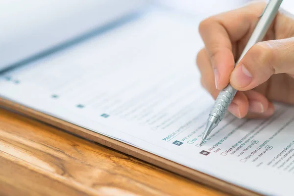 Mano con pluma sobre formulario de solicitud  . — Foto de Stock