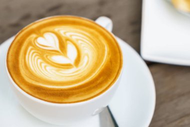 Ahşap masadaki Latte Kahve Sanatı