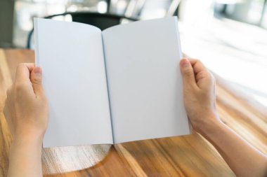 Ahşap masa üzerinde eller açık kitap .