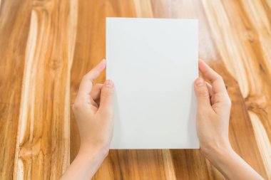 Ahşap masa üzerinde eller açık kitap .