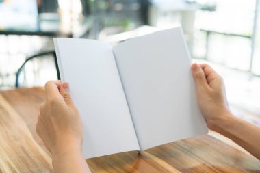 Ahşap masa üzerinde eller açık kitap .