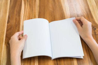Ahşap masa üzerinde eller açık kitap .