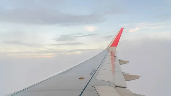 Asa de um avião voando acima das nuvens . — Fotografia de Stock