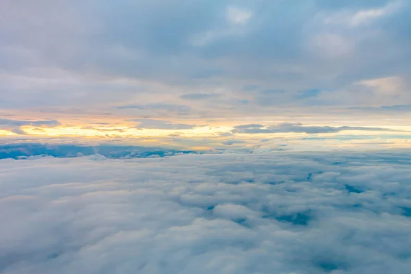 Salida del sol sobre las nubes desde la ventana del avión . —  Fotos de Stock