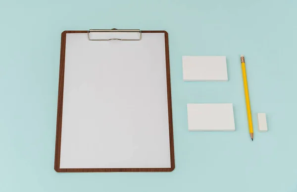 Clip board, paper,pencil  and business card on blue background . — Stock Photo, Image