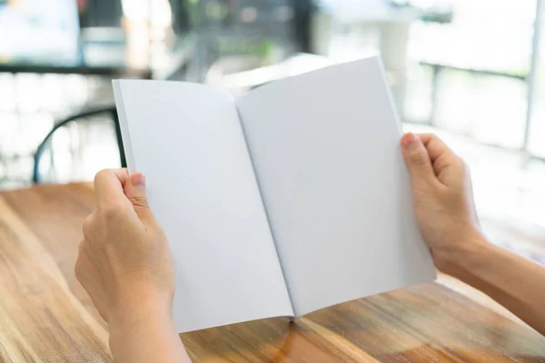 Manos libro abierto sobre mesa de madera  . — Foto de Stock