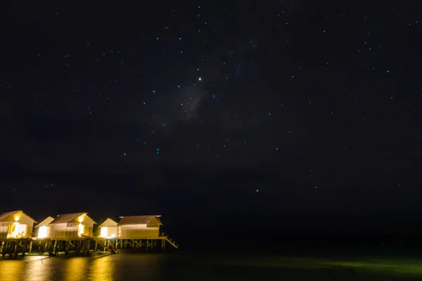 Abstract vervagen Melkweg boven water villa cottages op de Maldiven . — Stockfoto