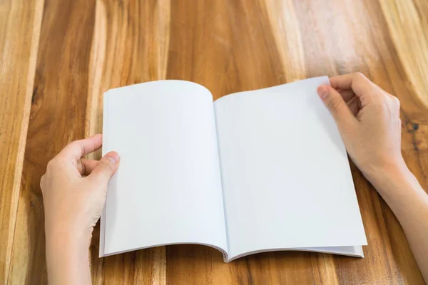 Mani aperte libro su tavolo in legno  . — Foto Stock