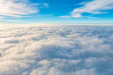 Uçak penceresinden bulutların üzerinde gün doğumu .