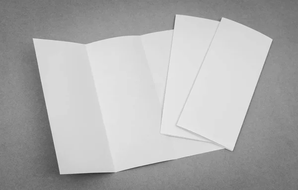 Potrójnie składany papier biały szablon na szarym tle . — Zdjęcie stockowe