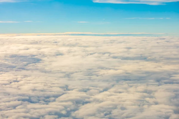 Salida del sol sobre las nubes desde la ventana del avión . — Foto de Stock