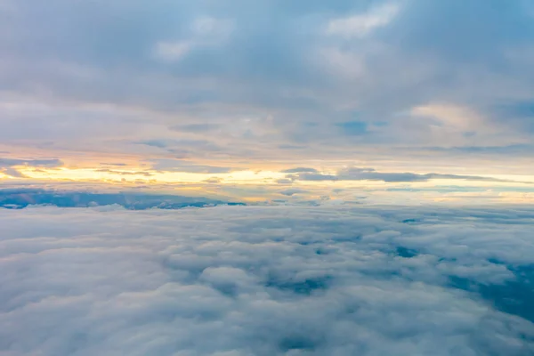 Salida del sol sobre las nubes desde la ventana del avión . —  Fotos de Stock