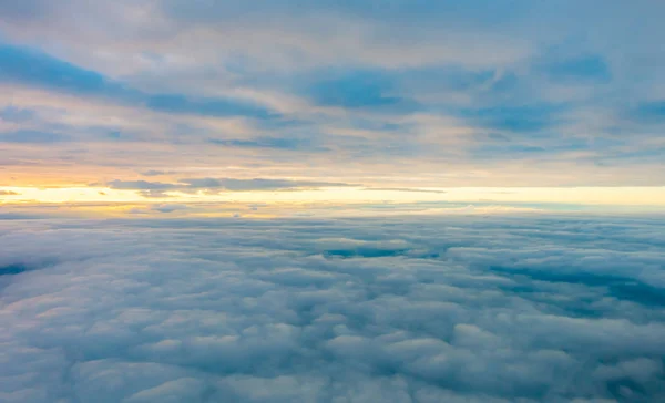 Napfelkelte a felhők felett a repülőgép ablakából . — Stock Fotó
