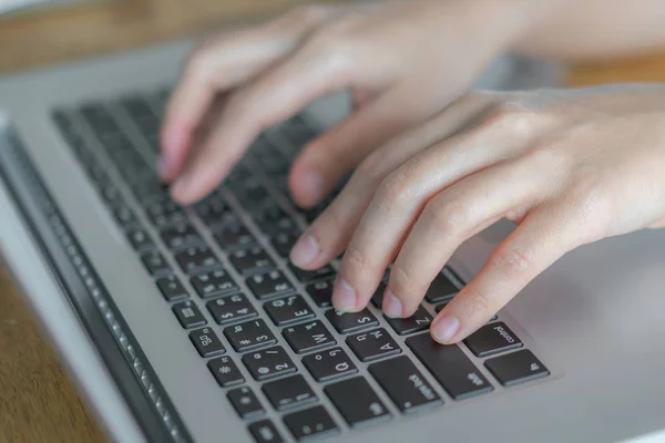Primo piano della mano della donna d'affari che digita sulla tastiera del computer portatile . — Foto Stock