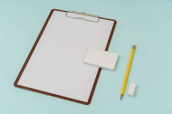 Clipboard, Papier, Bleistift und Visitenkarte auf blauem Hintergrund . — Stockfoto