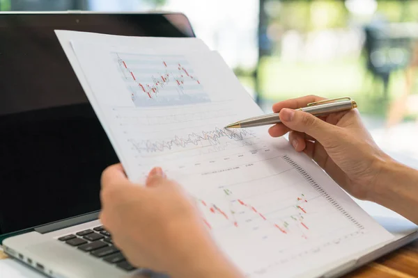 Geschäftsfrau mit Finanzdiagrammen und Laptop auf dem Tisch — Stockfoto