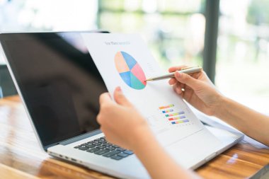 Kapalı toplantıda laptop ve mali grafikleri kullanarak iş adamları