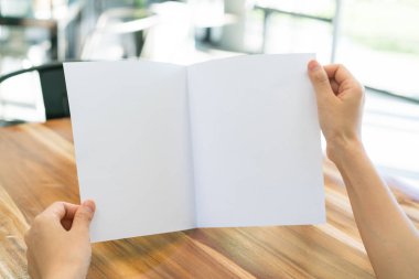 Kadın el tutun Bifold beyaz şablon kağıt üzerinde ahşap doku .