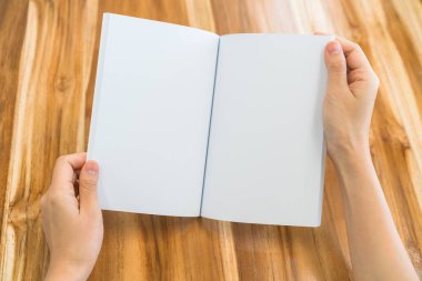Ahşap masa üzerinde eller açık kitap .