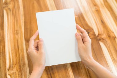 Ahşap masa üzerinde eller açık kitap .