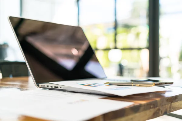 Gráficos financeiros na mesa com laptop  . — Fotografia de Stock