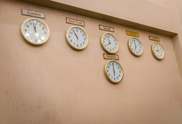 Klockor visar olika tidszoner på gammal vägg . — Stockfoto