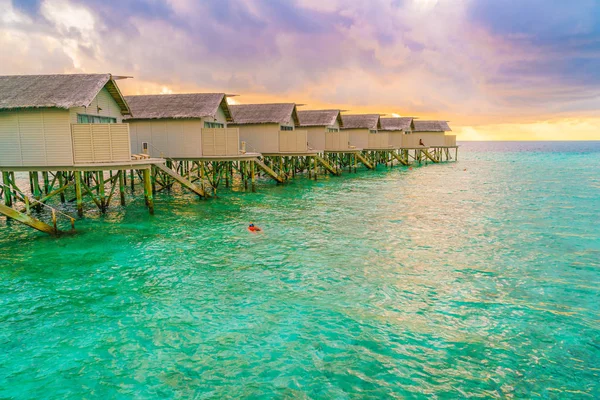 Schöne Wasservillen auf tropischen Malediven-Insel bei Sonnenuntergang — Stockfoto