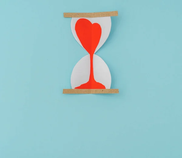 Découpe de papier de coeurs dans l'horloge de sable  . — Photo