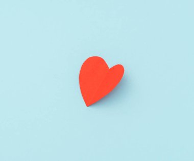 Mavi arka plan üzerinde kırmızı kağıt origami kalp .