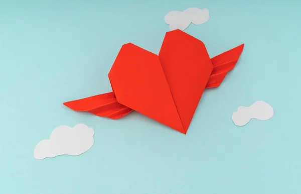 Rode papieren origami hart met vleugels en wolk op blauwe achtergrond — Stockfoto