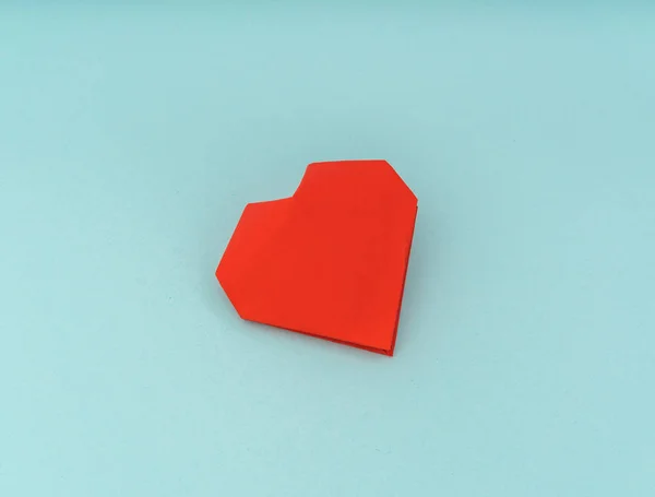 Papel rojo origami corazón sobre fondo azul  . —  Fotos de Stock