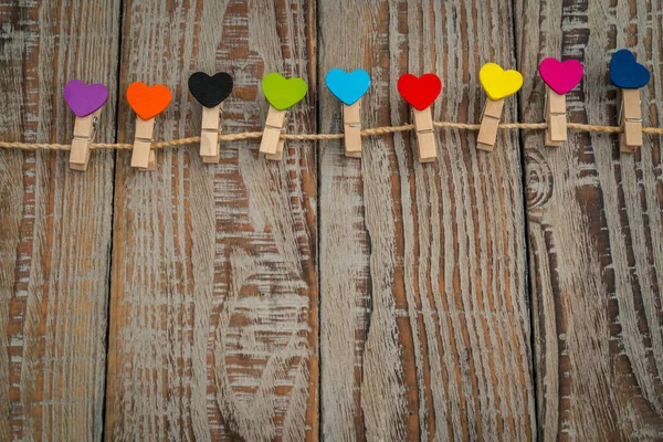 Corazón de papel rojo colgando sobre fondo de madera  . — Foto de Stock