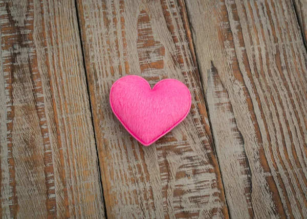 Rosa hjärta kudde på trä bakgrund . — Stockfoto