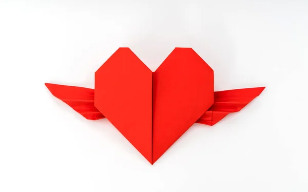 Corazón de origami de papel rojo con alas sobre fondo blanco  . — Foto de Stock